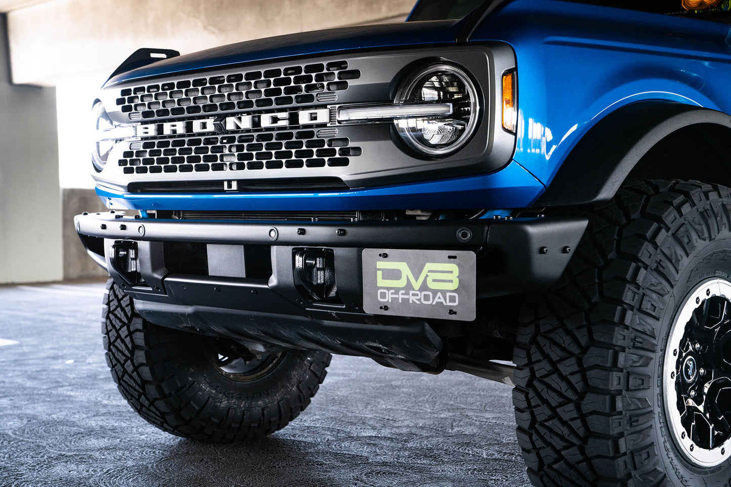 Front license plate relocation bracket places plate to the side of the bumper. by DV8 Offroad