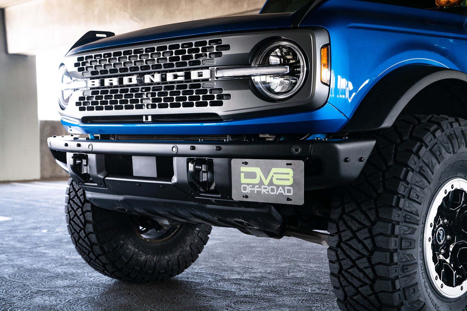 Front license plate relocation bracket places plate to the side of the bumper. by DV8 Offroad