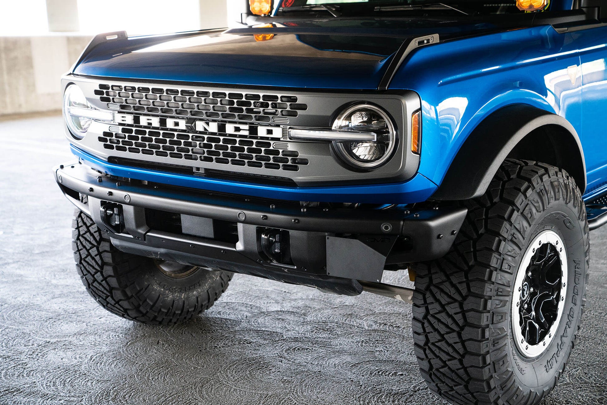 Front license plate relocation bracket places plate to the side of the bumper. by DV8 Offroad