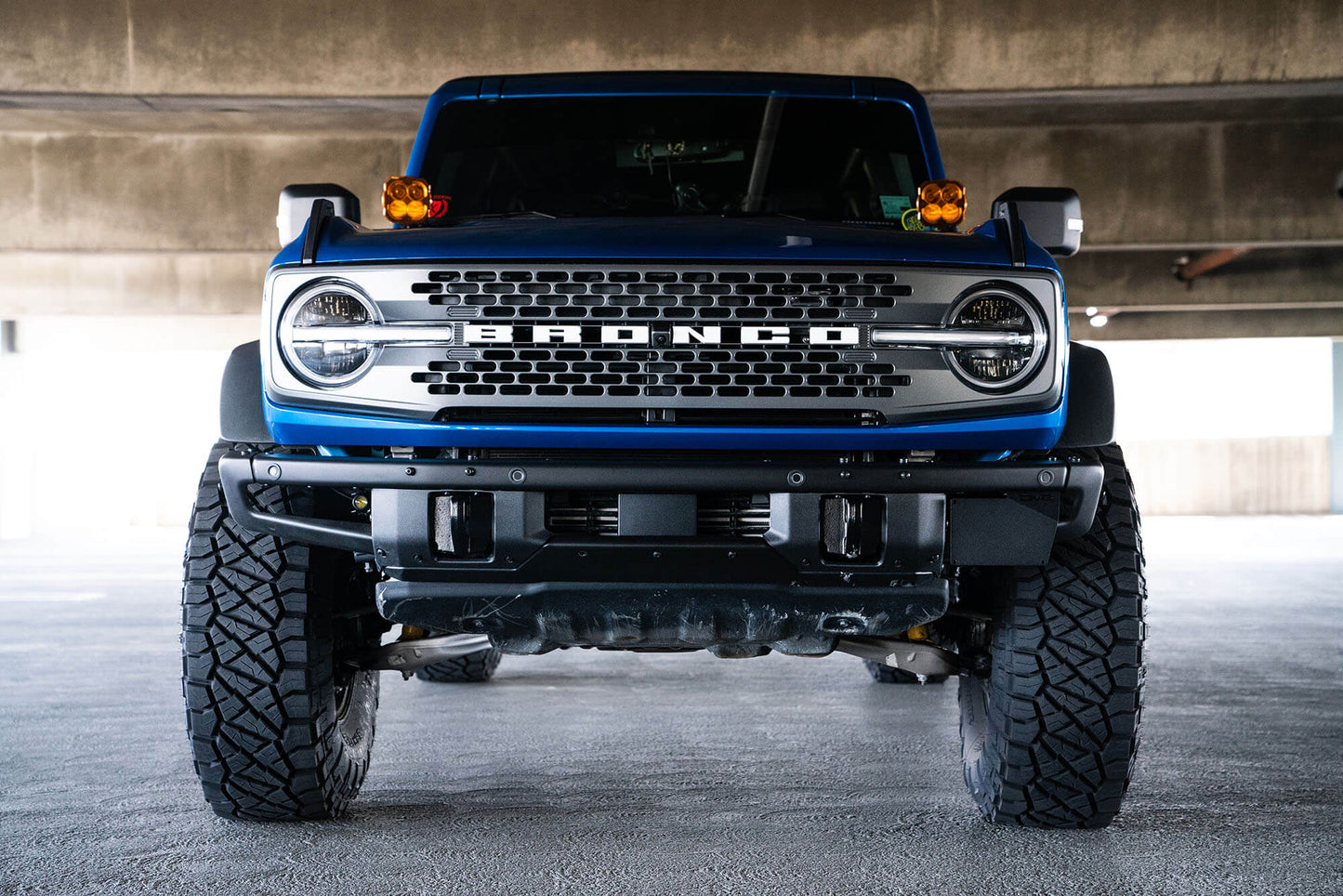 Front license plate relocation bracket places plate to the side of the bumper. by DV8 Offroad