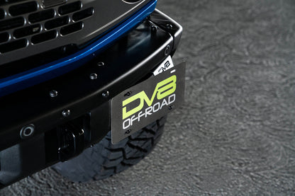 Front license plate relocation bracket places plate to the side of the bumper. by DV8 Offroad