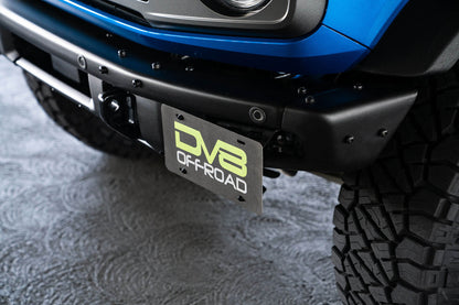 Front license plate relocation bracket places plate to the side of the bumper. by DV8 Offroad